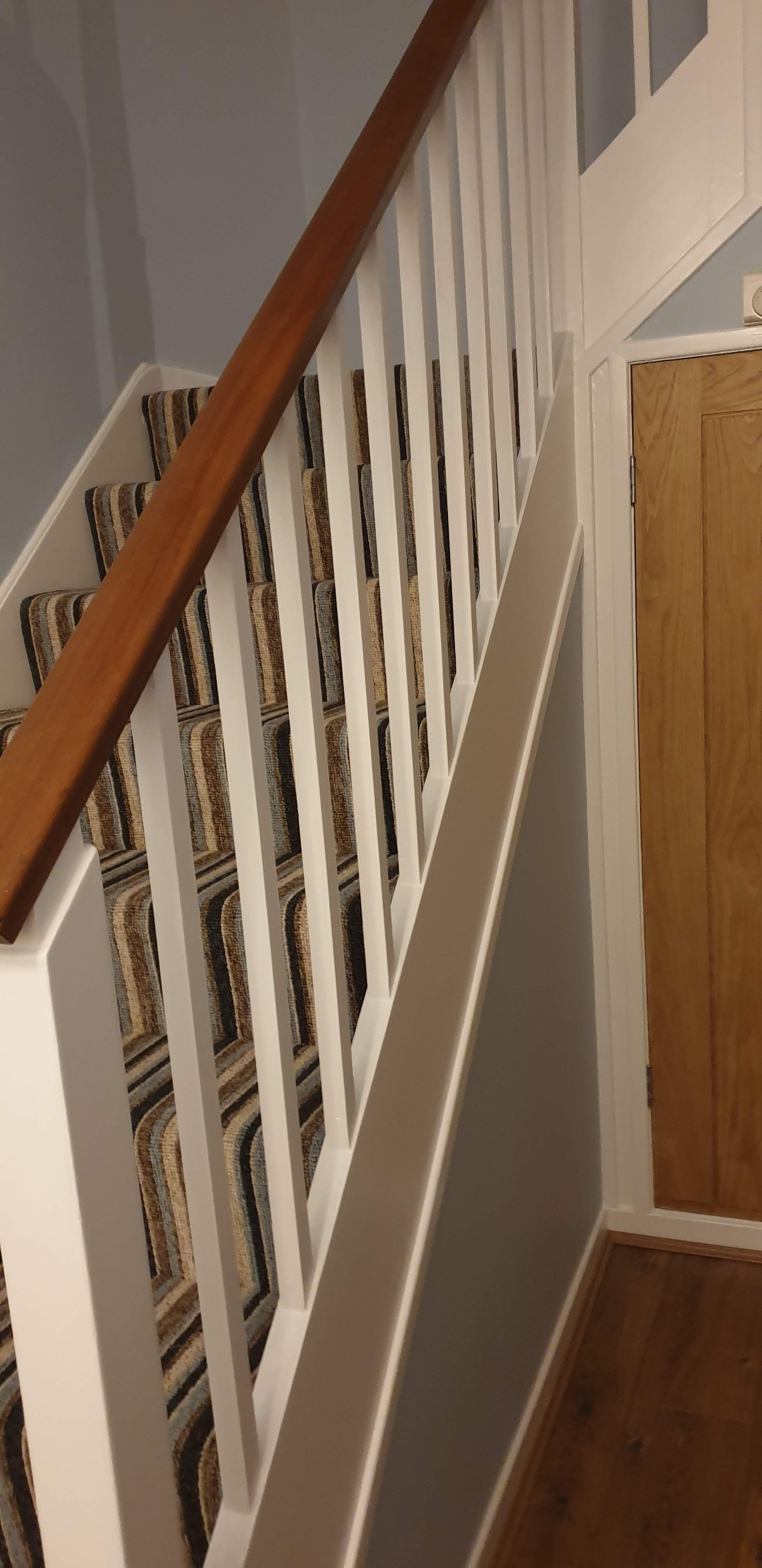 Staircase with white painted spindles and an oak handrail