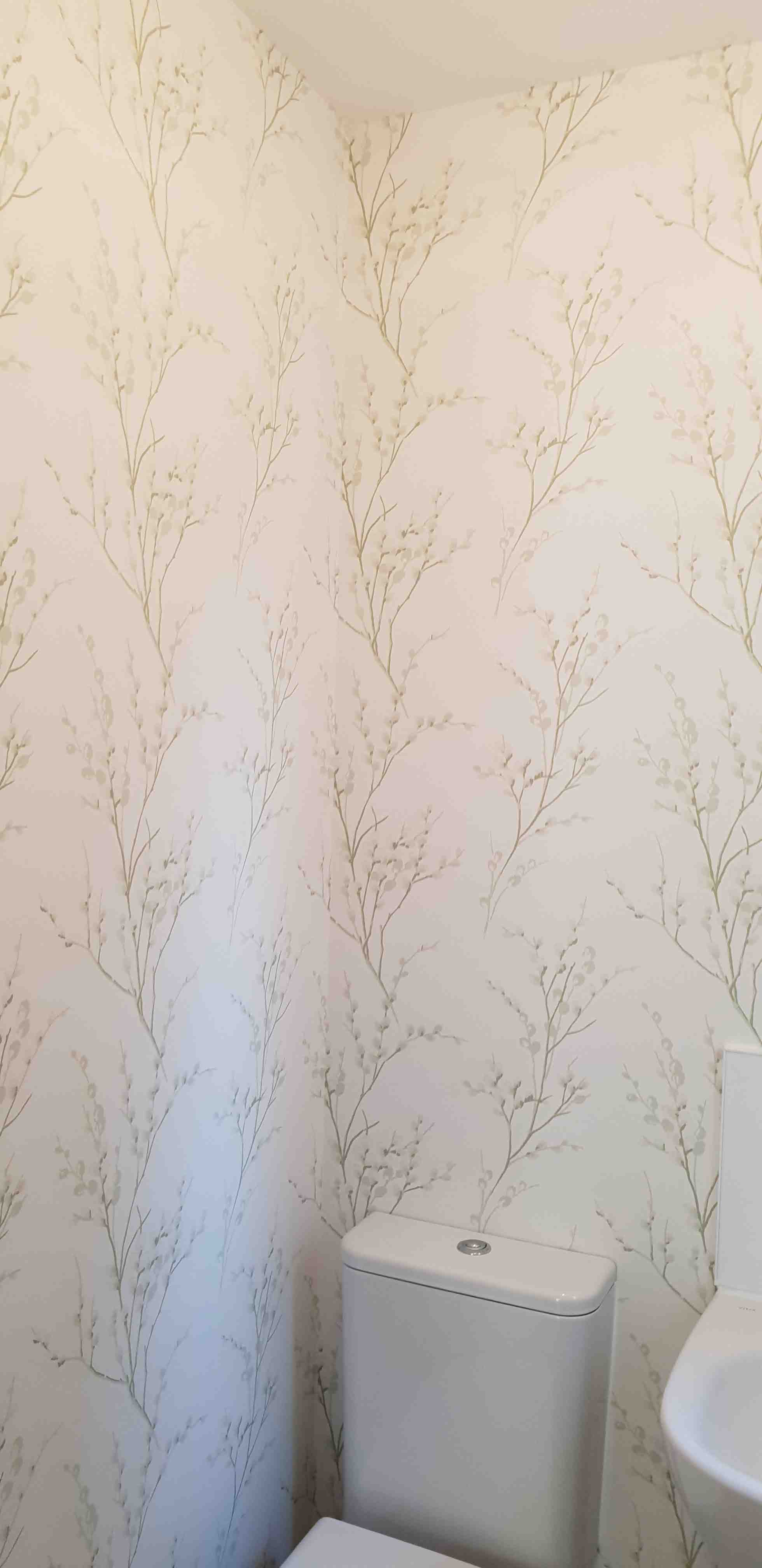 Cloakroom papered in a pale botanical wallpaper