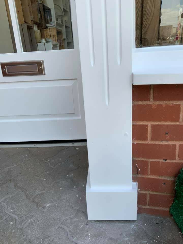 Glossy white front door and painted porch pillar